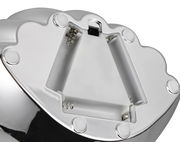 Nahaufnahme der Unterseite einer Tischleuchte mit Batteriefach und glänzender Metalloberfläche.