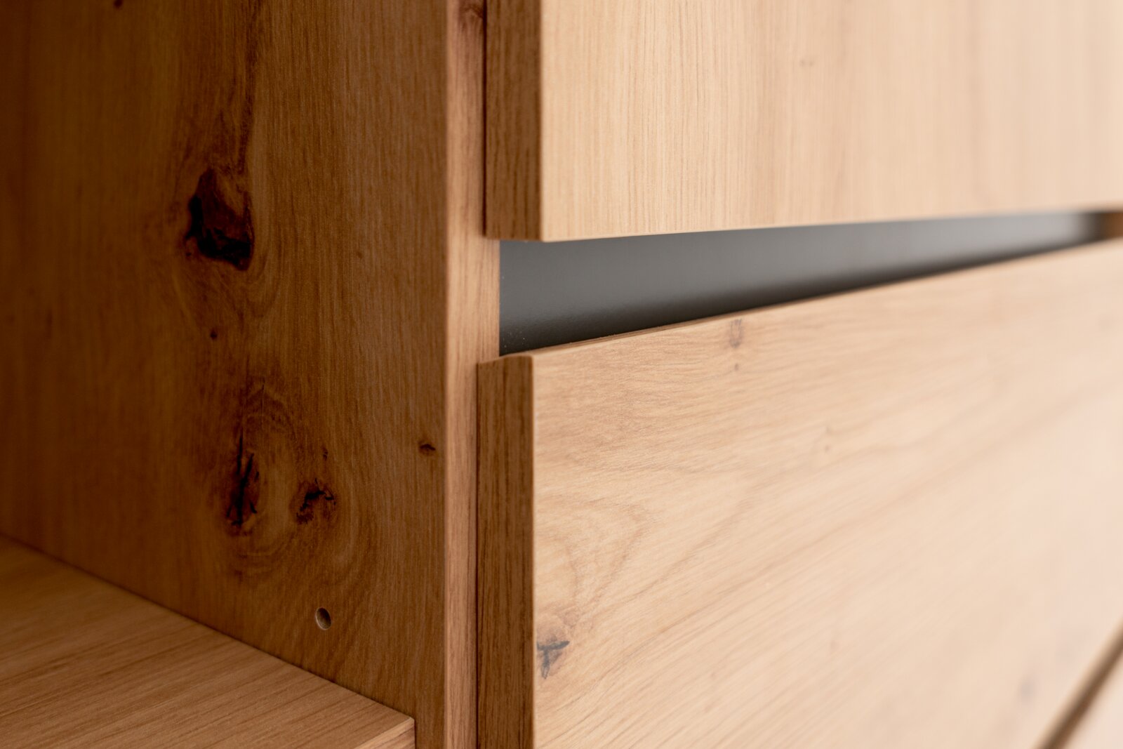 Nahaufnahme eines Highboards aus Holz mit natürlicher Maserung, seitliche Perspektive.