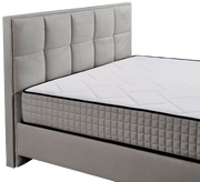 Graues Boxbett mit gestepptem Kopfteil und Matratze, seitliche Perspektive