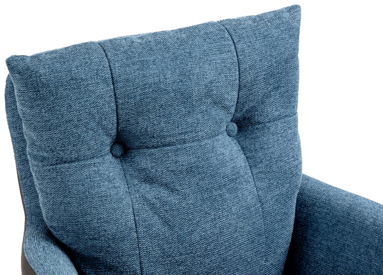 Nahaufnahme eines blauen Sessels mit Knopfdetails auf der Rückenlehne, von oben betrachtet.