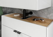 Nahaufnahme eines modernen Waschbeckenunterschranks mit Holzoberfläche und schwarzem Rohr, von vorne betrachtet.