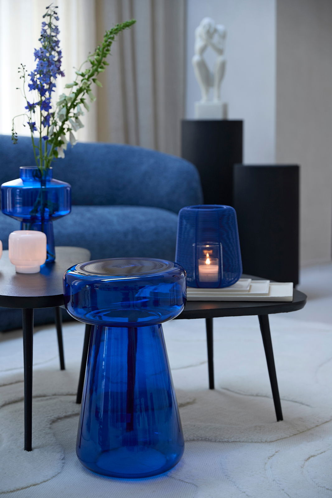 Blaue Glasschale in moderner Wohnzimmerumgebung, seitliche Perspektive