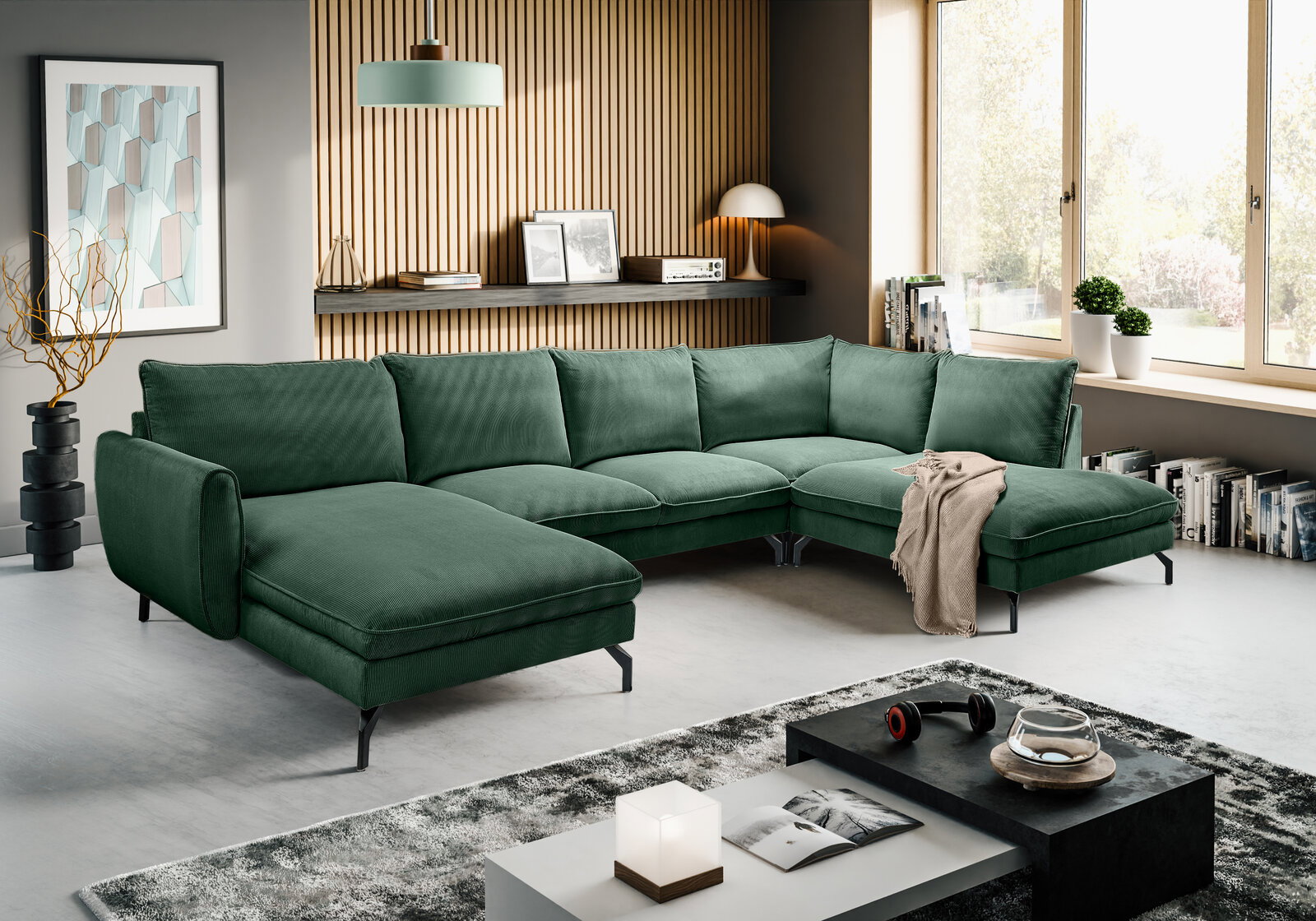 Grünes L-förmiges Ecksofa mit Cordbezug und schwarzen Metallfüßen in modernem Wohnzimmer, Perspektive: frontale 3/4-Ansicht von leicht links.