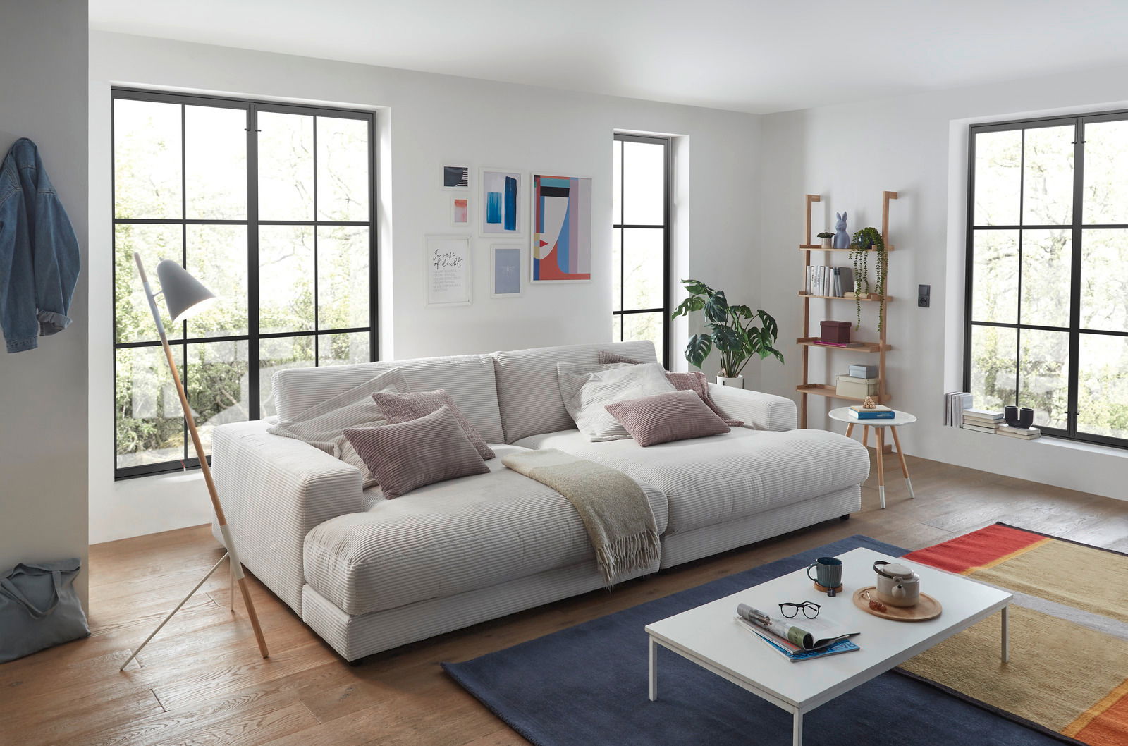 Gemütliches kleines Megasofa in einem modernen Wohnzimmer, seitliche Perspektive.