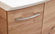 Nahaufnahme eines Badezimmerschranks mit Holzoptik und einem modernen, gebogenen Metallgriff.