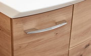 Nahaufnahme eines Badezimmerschranks mit Holzoptik und einem modernen, gebogenen Metallgriff.