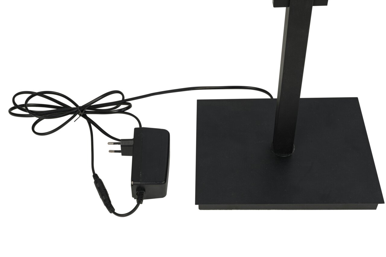 Close-up van de voet van een led-staande lamp met een zwarte rechthoekige voet en een netsnoer. Aanzicht van bovenaf.
