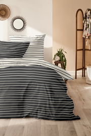 Bettwäsche-Set mit schwarz-weißen Streifen, frontal fotografiert in einem stilvoll eingerichteten Schlafzimmer.