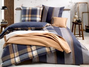 Bed met omkeerbaar beddengoed in blauw- en bruintinten, geruit en gestreept patroon, zijaanzicht