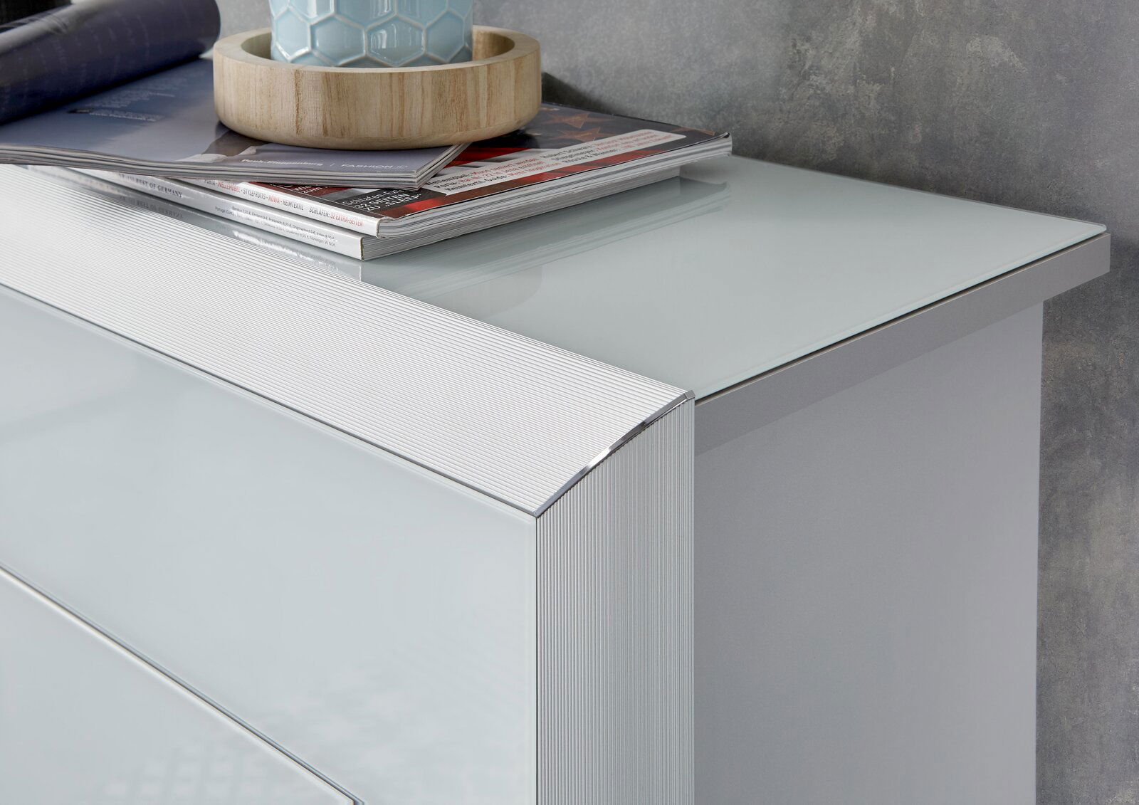 Nahaufnahme eines modernen Schuhschranks mit glänzender Glasoberfläche und eleganten Linien, von oben betrachtet.