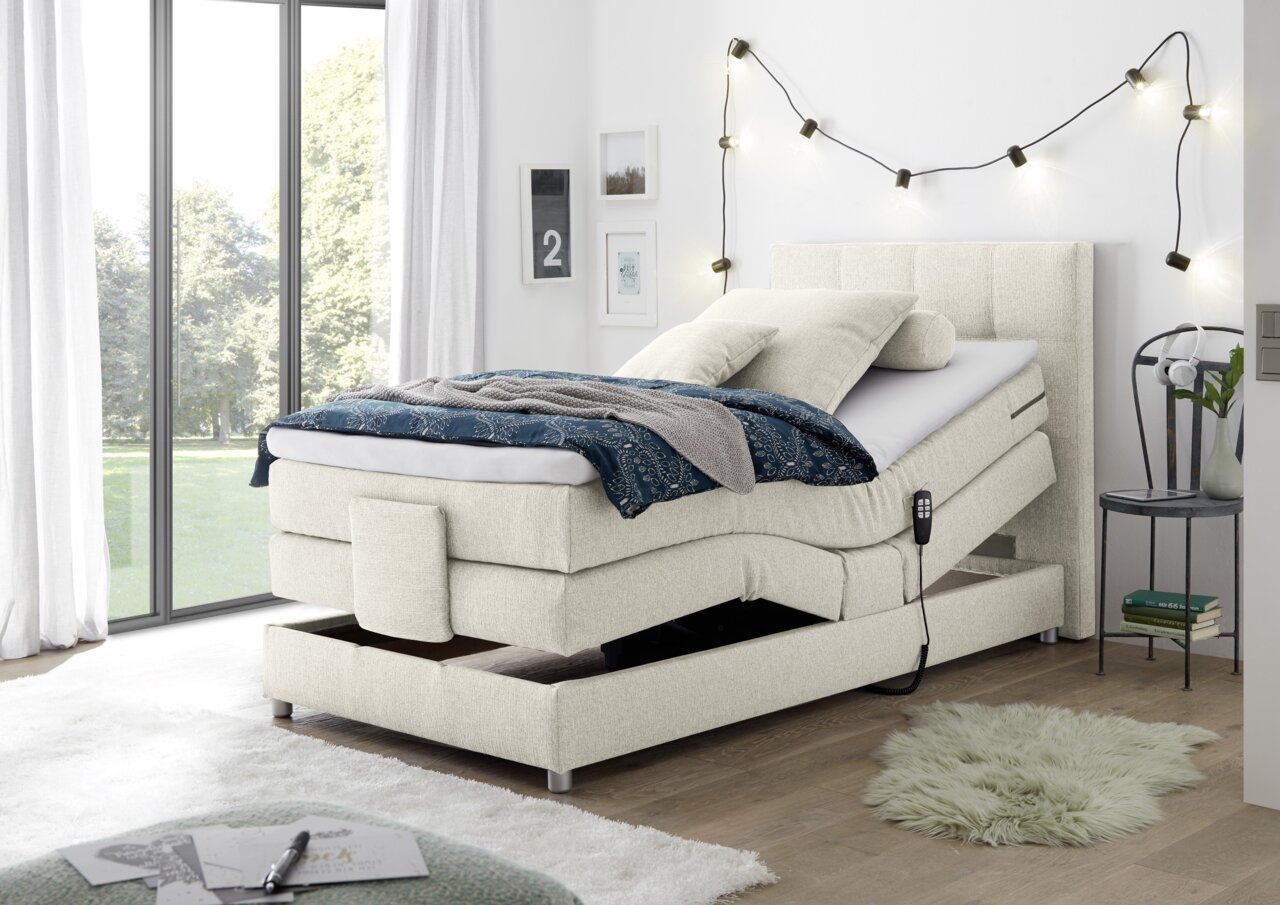 Boxspringbett mit verstellbarem Kopfteil in einem modernen Schlafzimmer, seitliche Perspektive