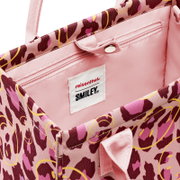 Innenansicht einer rosa Shopper-Tasche mit Leopardenmuster und Smiley-Print, mit Reißverschluss-Innentasche und „reisenthel SMILEY“-Label, Nahaufnahme aus schräger Draufsicht.