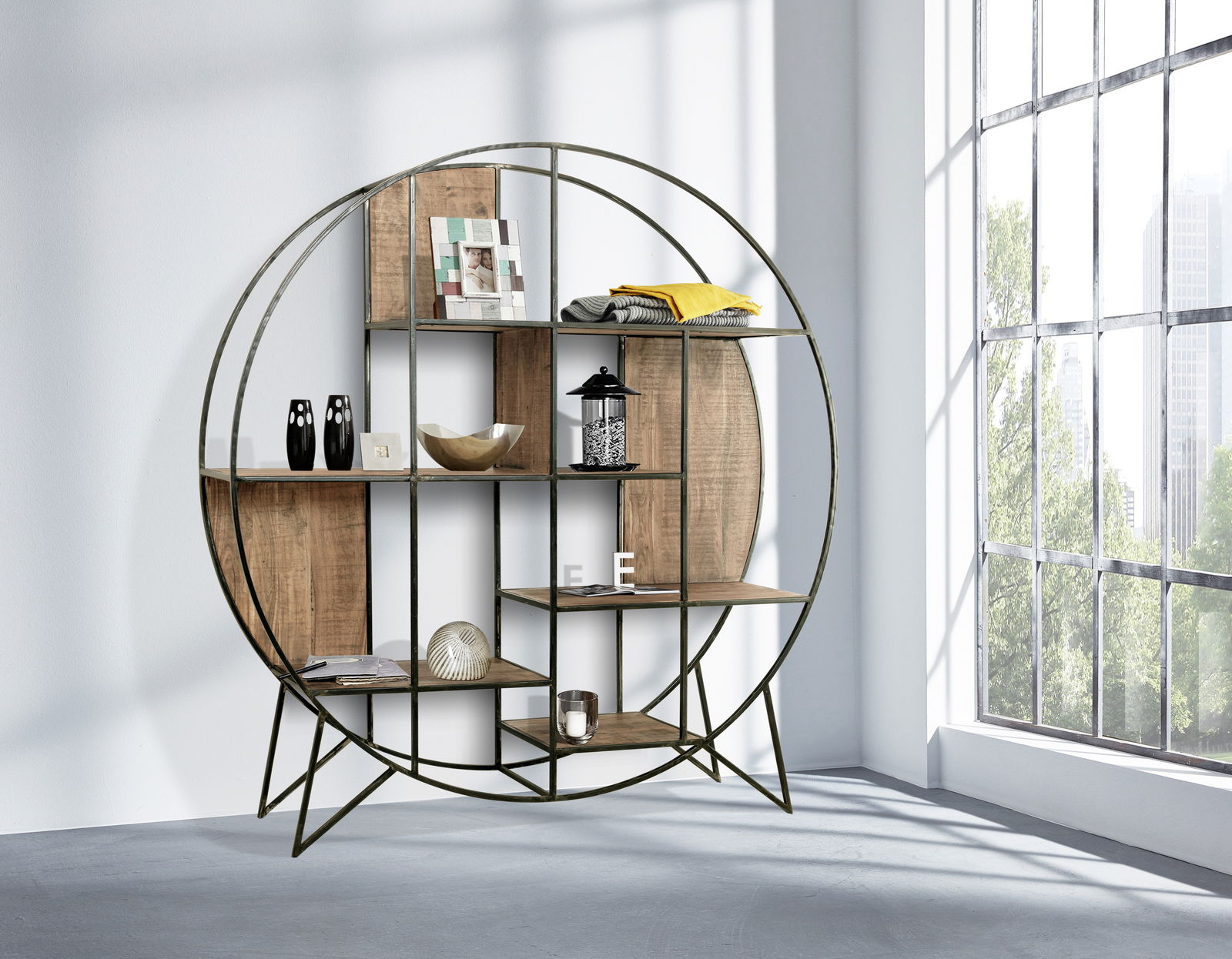 Rundes Regal aus Metall und Holz, seitliche Perspektive, mit dekorativen Gegenständen gefüllt, in einem hellen Raum mit großen Fenstern.