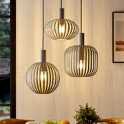 Drei moderne Pendelleuchten mit grauem, lamellenförmigem Käfigschirm und warm leuchtenden Glühbirnen vor heller Wand, Innenraumaufnahme in leicht seitlicher Frontansicht von unten.