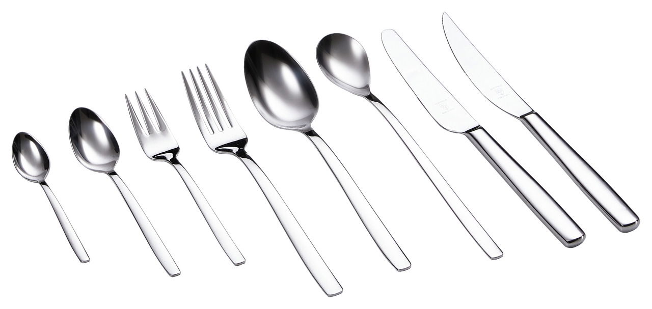 Ein 48-teiliges Besteckset aus Edelstahl, bestehend aus Löffeln, Gabeln und Messern, in einer seitlichen Perspektive angeordnet.