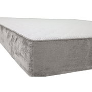 Gepolsterter, grauer Bettkasten/Boxspring-Unterbau mit weißer, gesteppter Liegefläche, fotografiert in seitlicher Perspektive von vorne links vor weißem Hintergrund