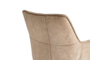 Nahaufnahme der Rückseite einer beige gepolsterten Stuhllehne mit sichtbaren Nähten, seitliche Ansicht vor weißem Hintergrund