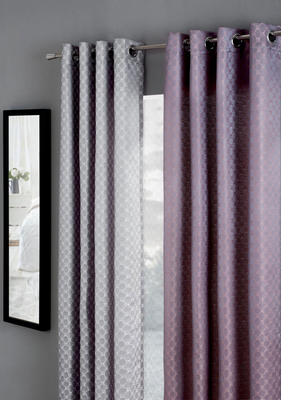 JOOP! Ösenschal J!Allover Zwei Vorhänge in Grau und Lila mit geometrischem Muster, aufgehängt an einer Gardinenstange, seitliche Perspektive.