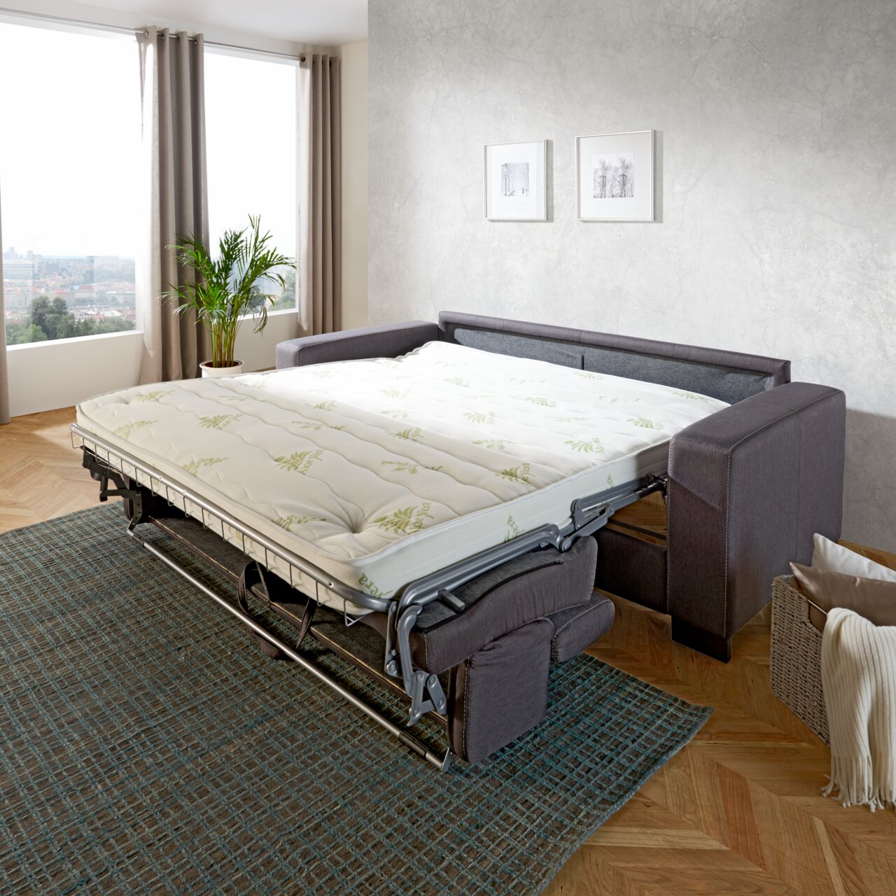 Funktionssofa in einem modernen Wohnzimmer, ausgeklappt als Bett, seitliche Perspektive