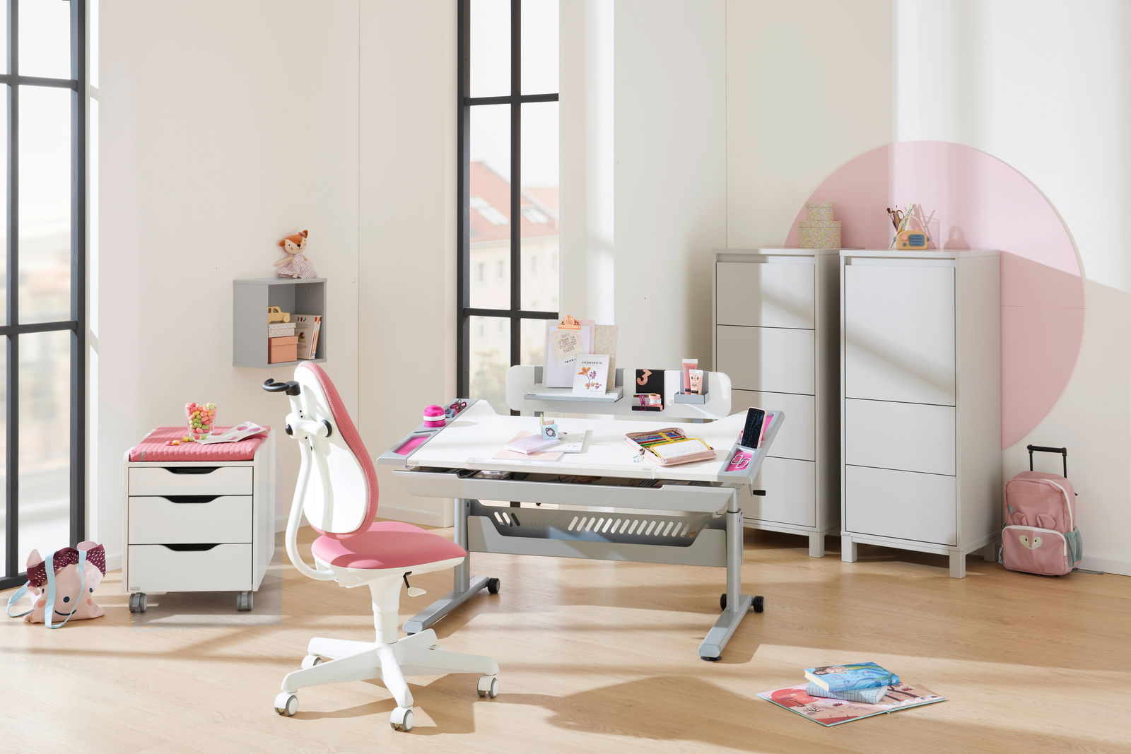 Moderner Jugenddrehstuhl in Weiß und Rosa, seitliche Perspektive, in einem hellen, stilvollen Kinderzimmer mit Schreibtisch und Regalen.