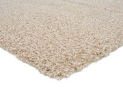 Nahaufnahme eines cremefarbenen Hochflor-Teppichs aus seitlicher Perspektive