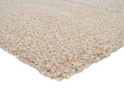 Nahaufnahme eines cremefarbenen Hochflor-Teppichs aus seitlicher Perspektive