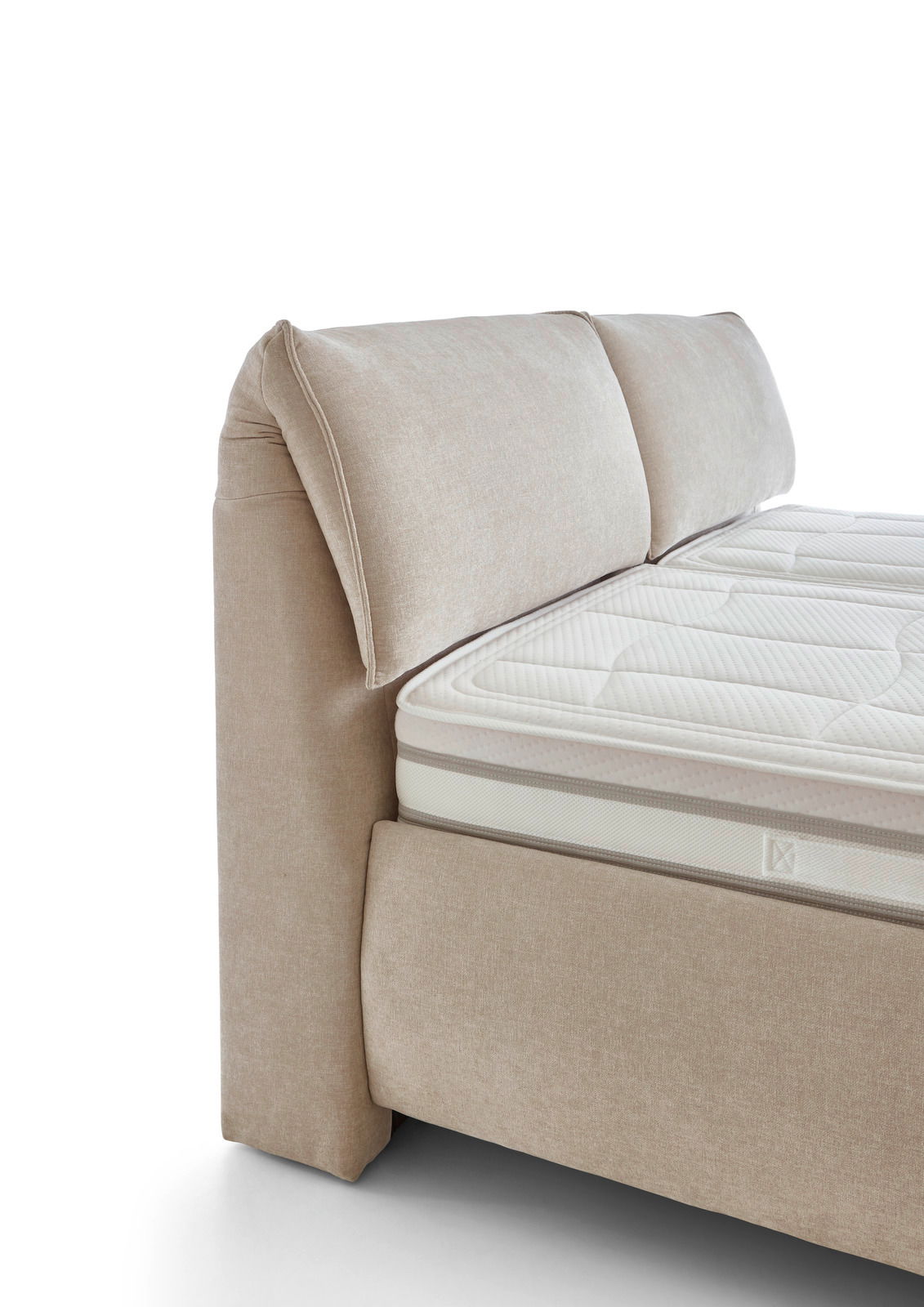 Seitliche Ansicht eines beigen Polsterbetts mit gepolstertem Kopfteil und Matratze.