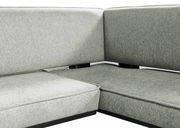 Nahaufnahme einer grauen Eckbank mit gepolsterten Sitz- und Rückenflächen, Perspektive von vorne.