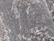 Nahaufnahme eines Designer Teppichs mit grauer und beiger Textur, seitliche Perspektive