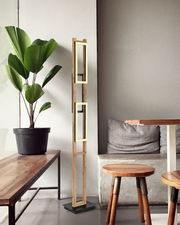 Moderne Stehleuchte aus Holz mit rechteckigen Rahmen, seitliche Perspektive, neben einem Tisch und einer Pflanze platziert.