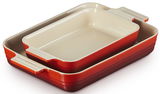 Zwei rechteckige Auflaufformen von Le Creuset in Rot und Creme, ineinander gestapelt, aus einer leicht schrägen Vogelperspektive.