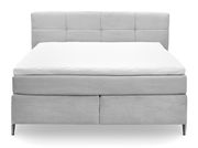 Frontale Ansicht eines grauen Boxspringbetts mit gestepptem Kopfteil und weißen Matratzenauflagen.