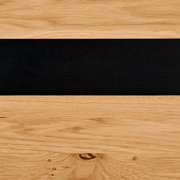 Detailfoto van een hoogkast met houtnerf en een zwarte sierstreep.