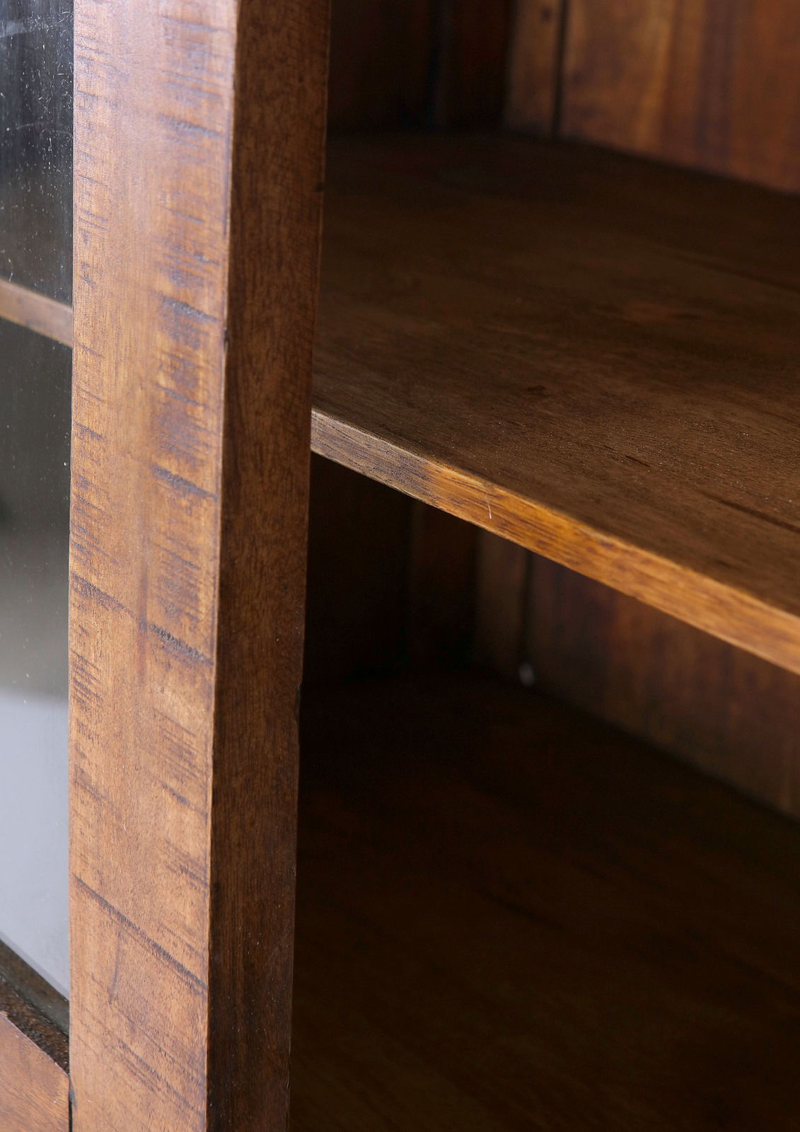 Nahaufnahme einer hölzernen Vitrine mit Glasfront, seitliche Perspektive