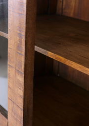 Nahaufnahme einer hölzernen Vitrine mit Glasfront, seitliche Perspektive