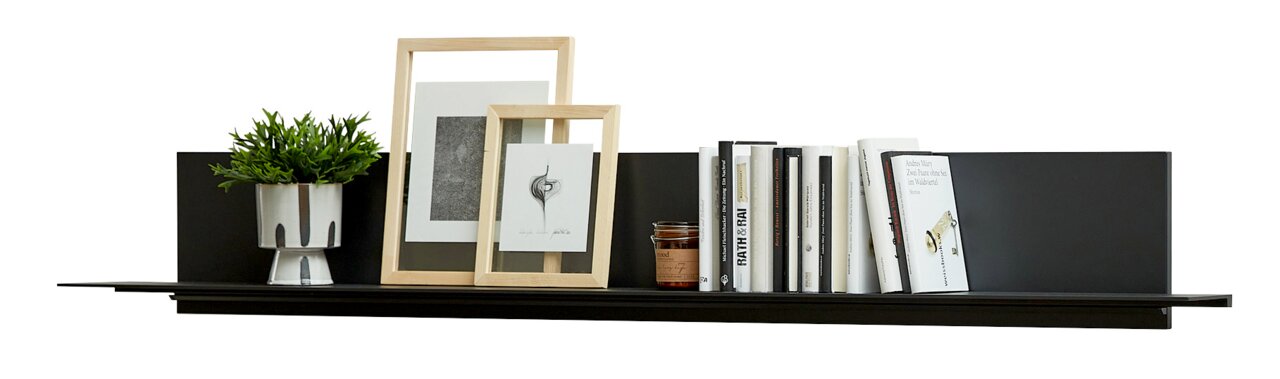 Venjakob Wandpaneel GAME Schwarzes Wandpaneel mit dekorativen Elementen wie Pflanzen, Bilderrahmen und Büchern, seitliche Perspektive.