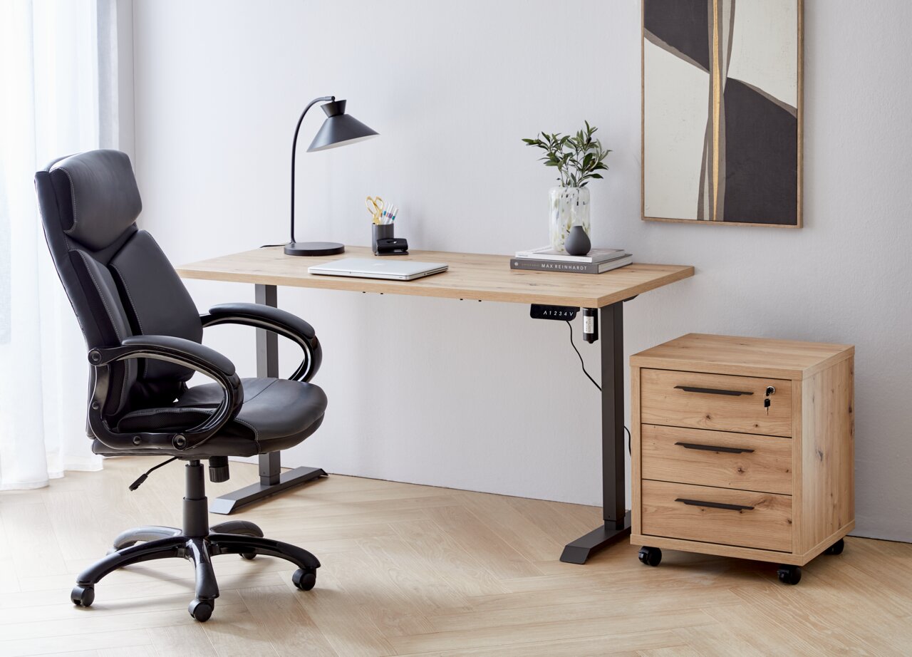 Moderner Arbeitsplatz mit höhenverstellbarer E-Tischplatte aus Holz, schwarzem Bürostuhl, Schreibtischlampe und Rollcontainer, seitliche Perspektive.