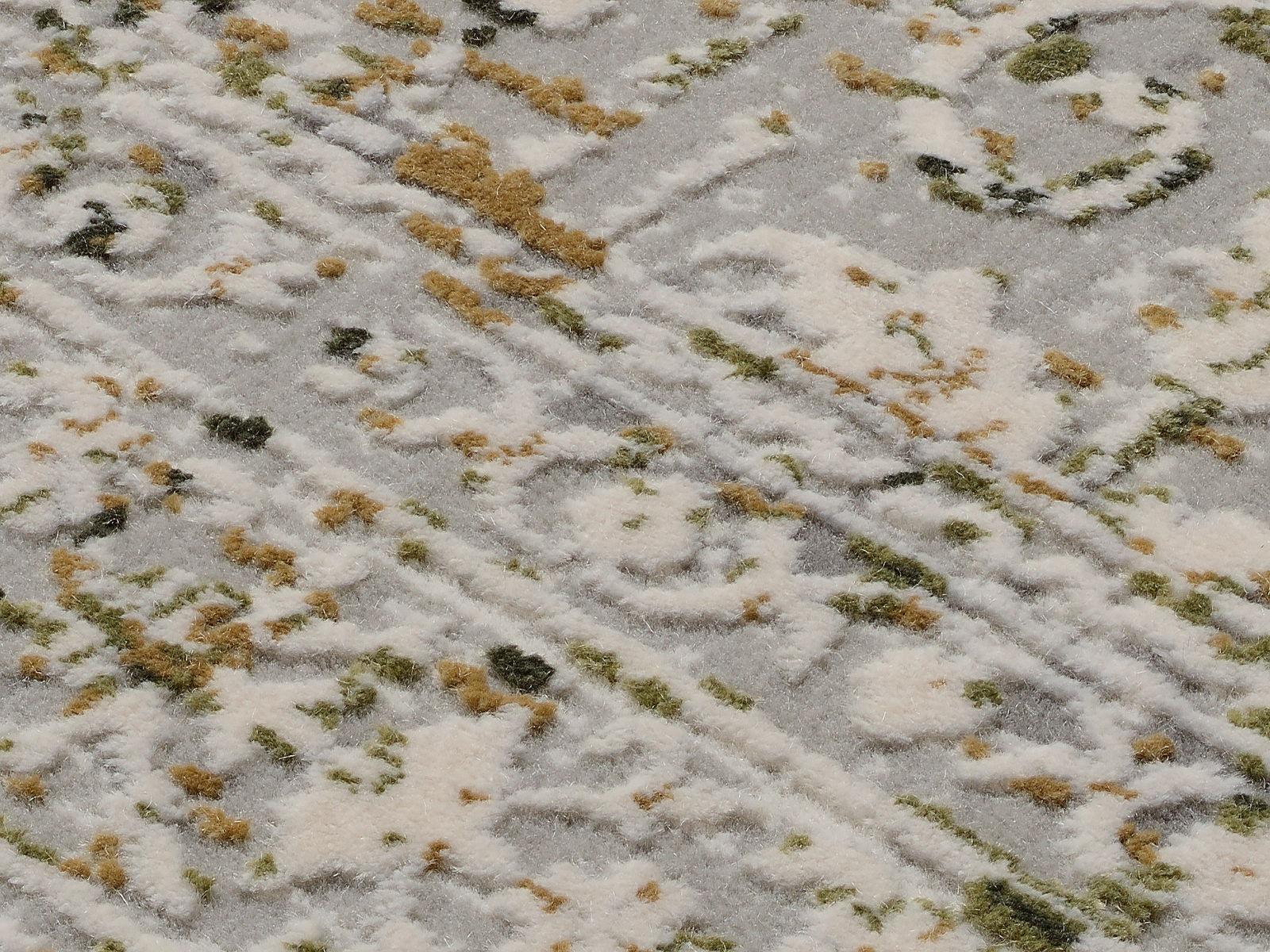 Nahaufnahme eines Designer-Teppichs mit abstraktem Muster in Weiß, Grün und Beige, aus schräger Perspektive fotografiert.