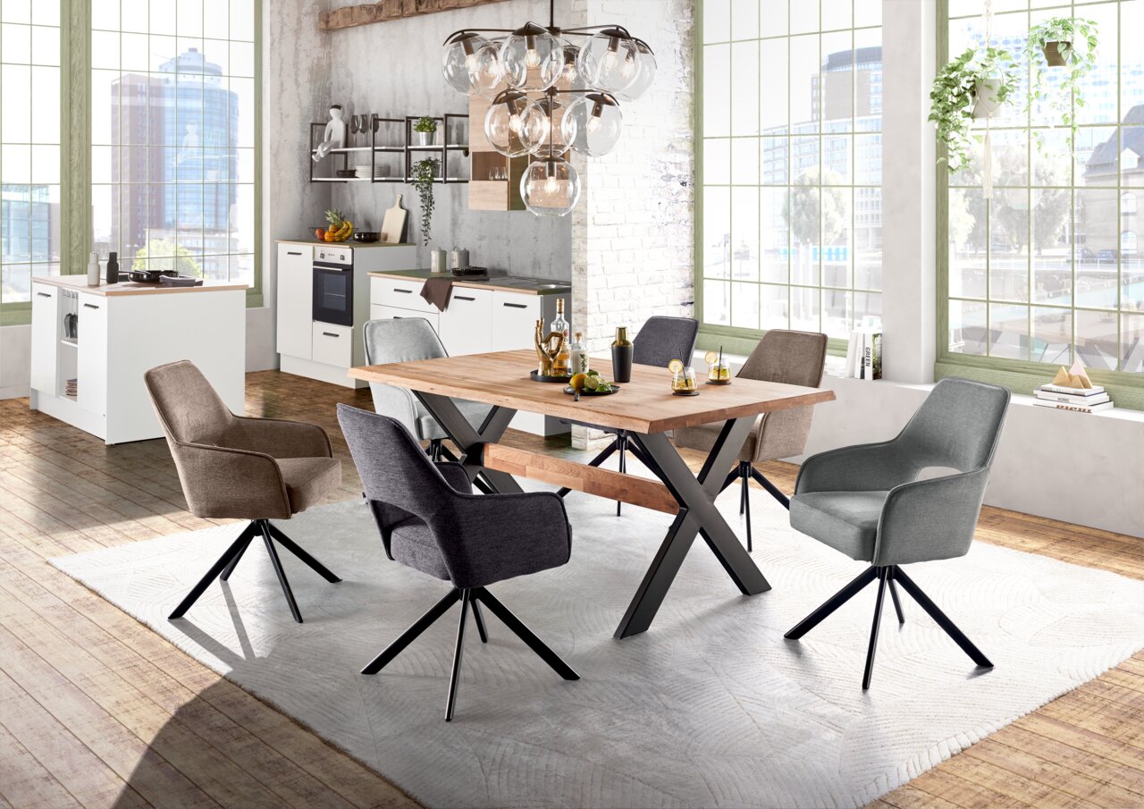 Esszimmer mit modernem Armlehnstuhl-Set in verschiedenen Farben um einen Holztisch, seitliche Perspektive
