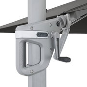 Nahaufnahme der Kurbel- und Getriebeeinheit eines Doppler-Sonnenschirms in Silber/Schwarz am Mast, seitliche Perspektive