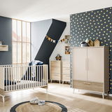 Moderner Kleiderschrank EEFJE in einem stilvollen Kinderzimmer, frontal abgebildet, mit zwei Türen und einer Schublade, umgeben von weiteren Möbeln und Dekorationen.