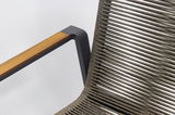 Nahaufnahme eines Stapelsessels mit einem modernen Design, das eine Kombination aus Holzarmlehne und geflochtenem Sitz zeigt, seitliche Perspektive.