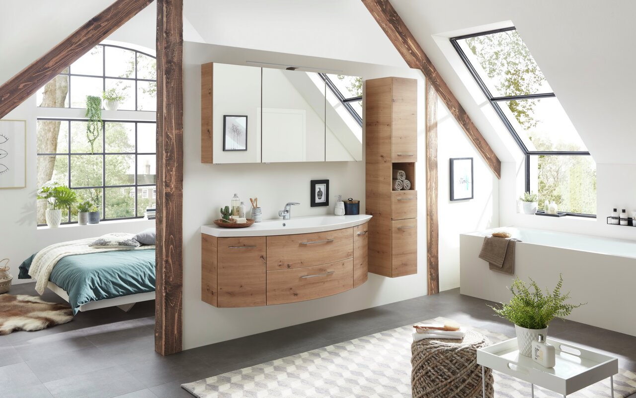 Moderne hoge kast met houtlook in een stijlvolle badkamer met schuin dak, zijaanzicht.