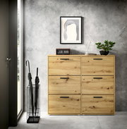 Schuhkipper aus Holz mit sechs Fächern, frontal fotografiert, in einem modernen Raum mit grauer Wand und Dekorationen.