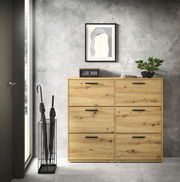 Schuhkipper aus Holz mit sechs Fächern, frontal fotografiert, in einem modernen Raum mit grauer Wand und Dekorationen.