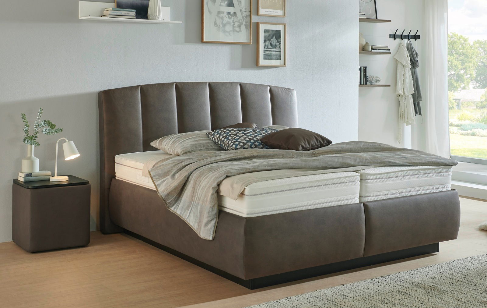 Modernes Polsterbett in einem stilvollen Schlafzimmer, seitliche Perspektive