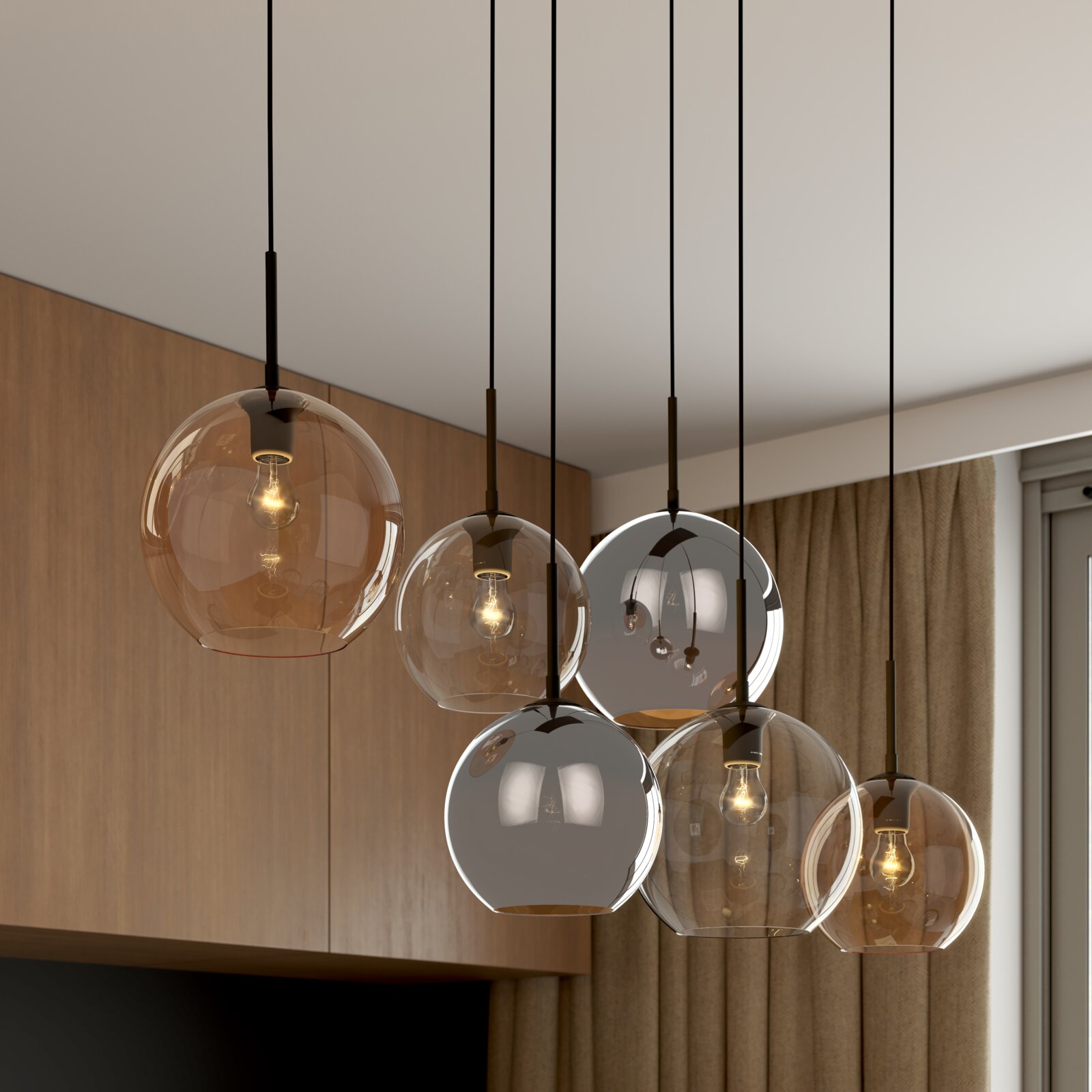 Moderne Cluster-Pendelleuchte mit mehreren kugelförmigen Glasschirmen in Rauch- und Amber-Optik, hängend an schwarzen Kabeln über einem Wohnbereich, Ansicht schräg von unten