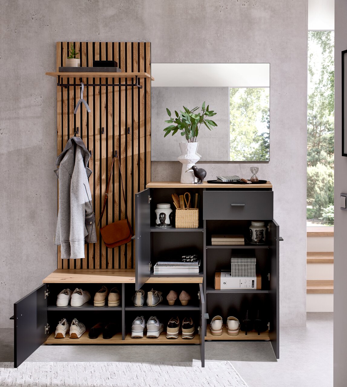 Kompaktgarderobe mit Holz- und Metallelementen, inklusive Schuhregal, Kleiderhaken und Spiegel, aus der Frontalperspektive fotografiert.