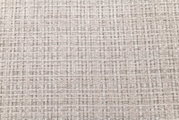 Nahaufnahme/Detailansicht von hellbeigem, grob gewebtem Polsterstoff mit strukturierter Tweed-Optik und dezentem Rastermuster