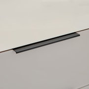 Detailaufnahme eines Schubladengriffs in mattem Schwarz an einer hellgrauen Schubladenfront, schräg von oben fotografiert